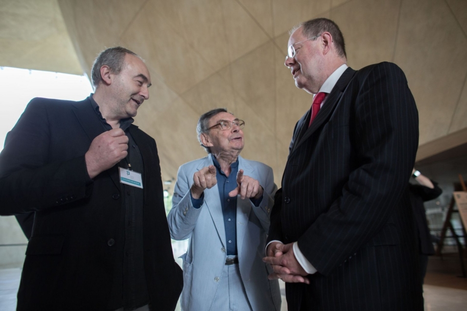 Marian Turski, Zygmunt Stępiński i trzeci mężczyzna rozmawiają w holu Muzeum POLIN.
