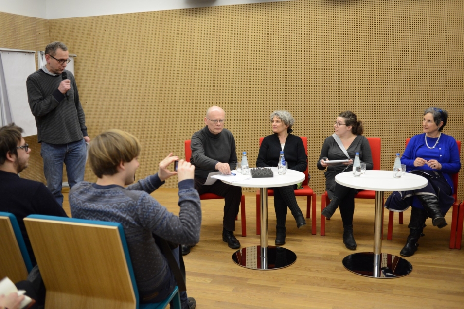 Moderator z mikrofonem w dłoni zadaje pytanie panelistom. 
