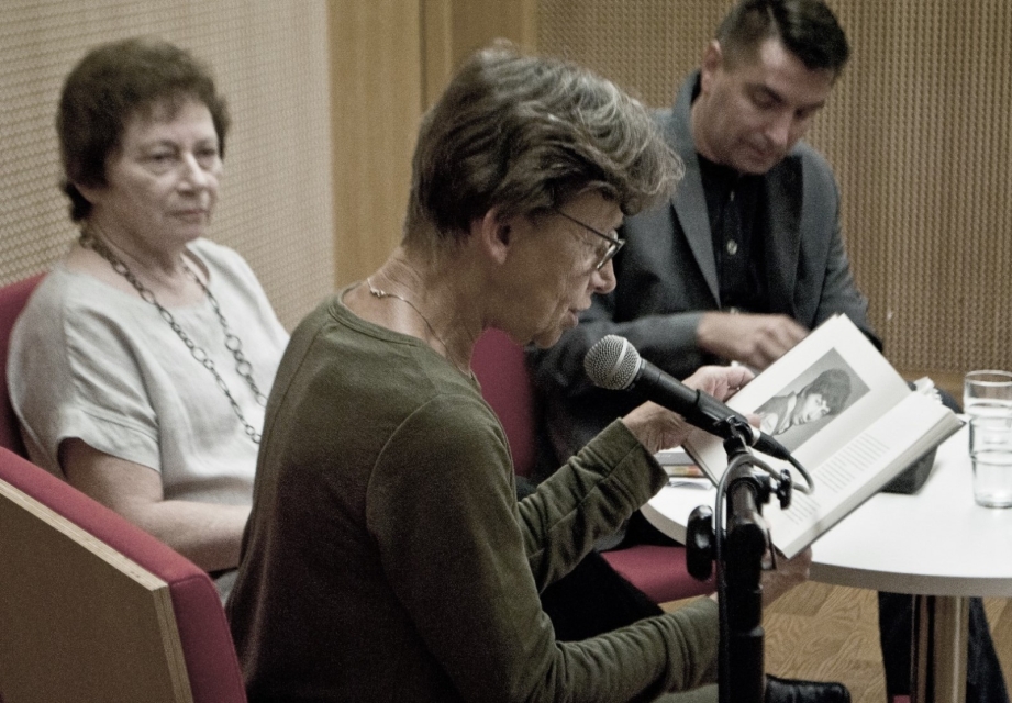 Kobieta czyta fragment książki przez mikrofon.