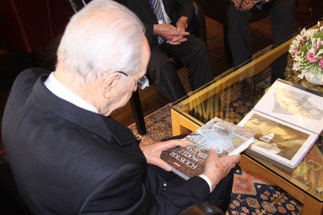 Mężczyzna ogląda Atlas historii Żydów polskich.