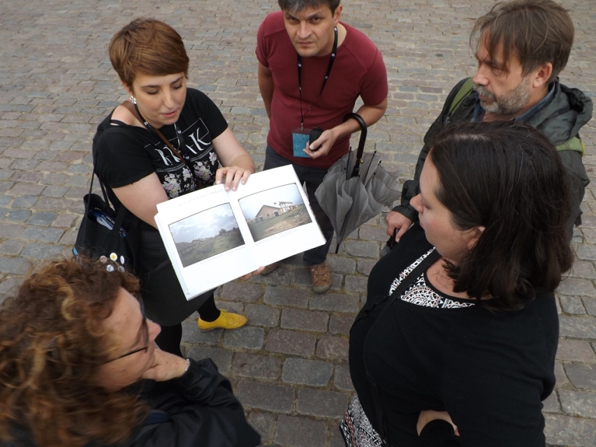 Kobieta pokazuje zdjęcia w albumie innym osobom.
