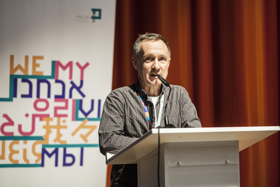 Mężczyzna przemawia przy mównicy podczas konferencji.