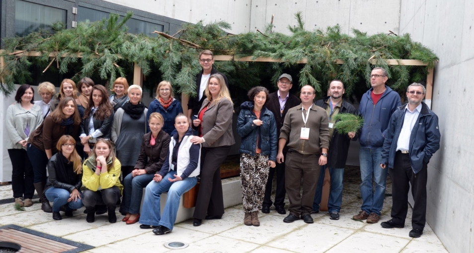 Grupa osób stoi przy szałasie zbudowanym z okazji święta Sukkot.