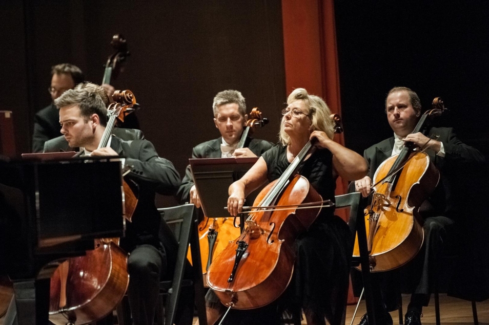 Koncert symfoniczny. Orkiestra na scenie, w tym kontrabasiści.