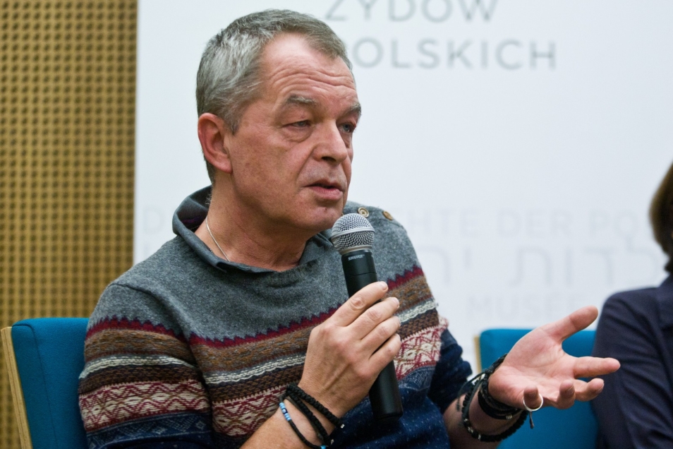 Mężczyzna mówi przez mikrofon.