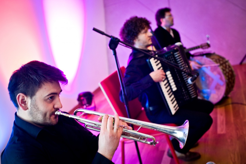 Trzej muzycy grają podczas interaktywnego koncertu towarzyszącemu wernisażowi.