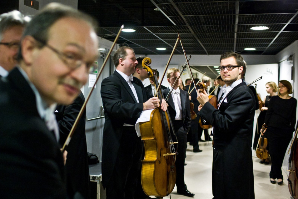Muzycy Sinfonia Varsovia stoją w korytarzu przed występem.