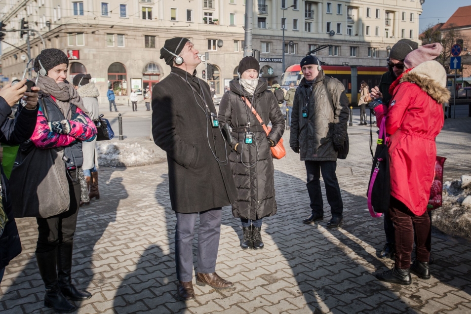 Kilka osób wraz z przewodnikiem na placu w czasie spaceru po dawnym getcie warszawskim
