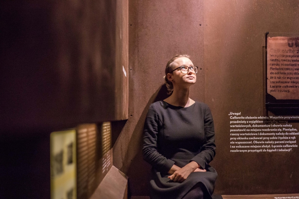 Kobieta opiera się o ścianę w galerii Zagłada w Muzeum POLIN.