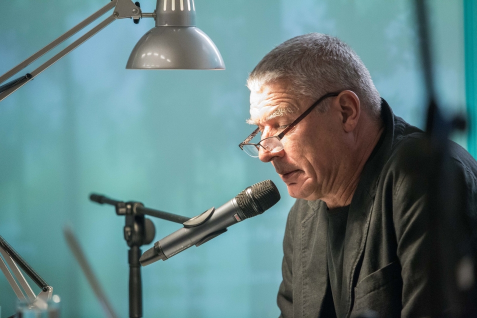 Mężczyzna mówi przez mikrofon.