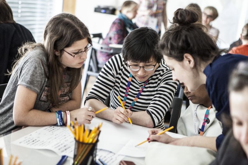 Kilka młodych osób pracuje w grupie podczas warsztatów.