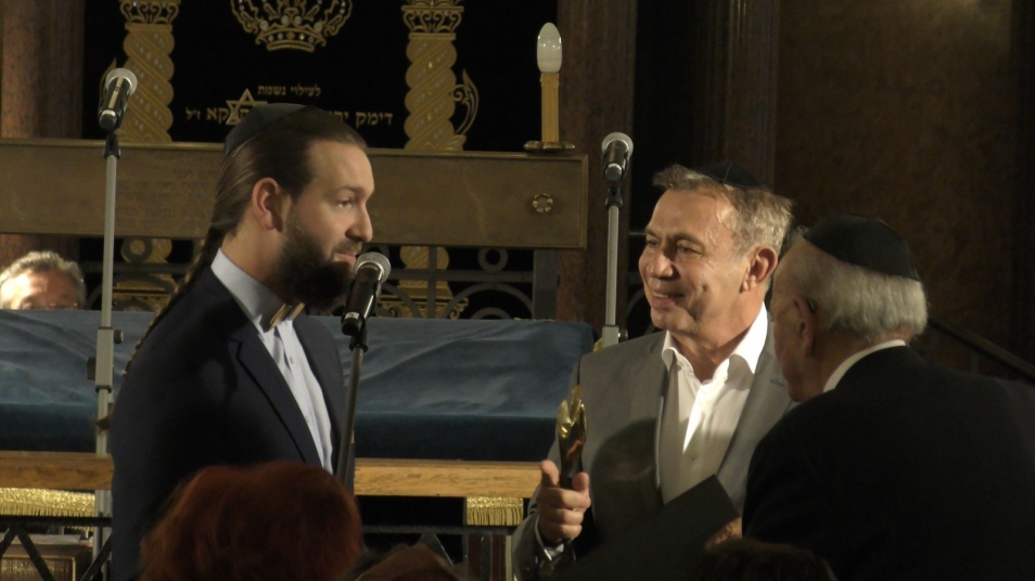 Trzech mężczyzn pogrążonych w rozmowie podczas gali Nagrody Strażnik pamięci.