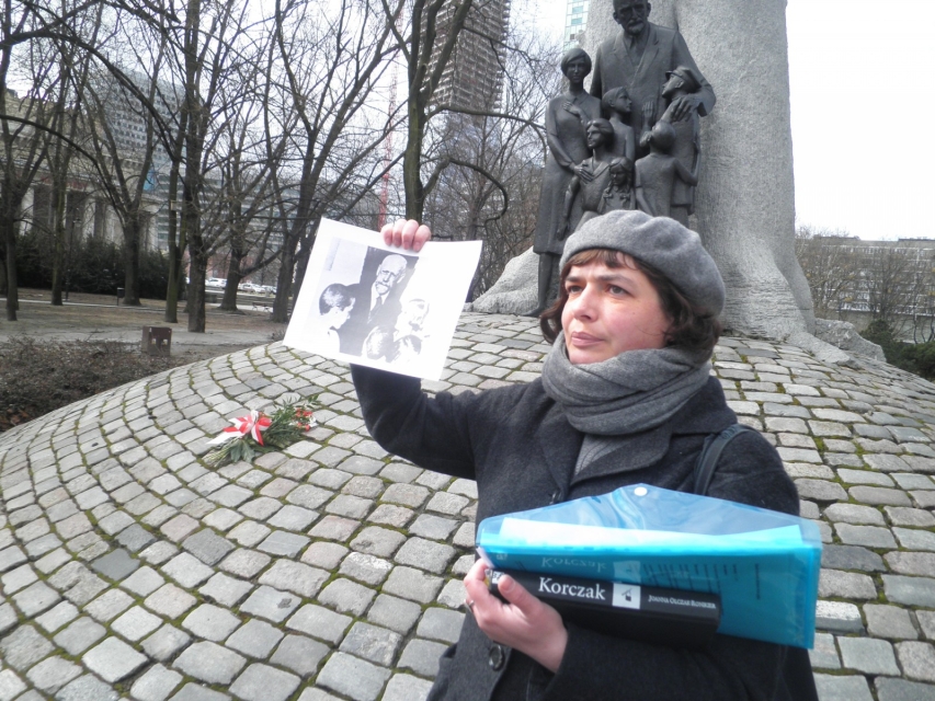 Przewodniczka pokazuje zdjęcie podczas spaceru dla szkół.