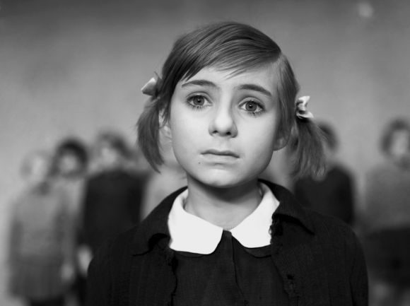 Czarno-biały kadr z filmu - dziewczynka z dwoma kucykami i w bluzce z białym kołnierzykiem.