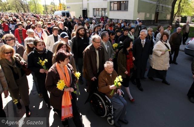 Ludzie idą, trzymając papierowe żonkile. Na czele Marek Edelman.