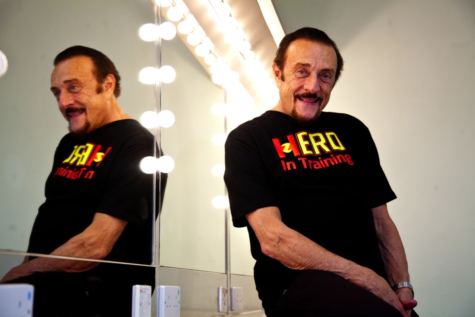 Philip Zimbardo opiera się o podświetlone lustro. Patrzy na wprost.