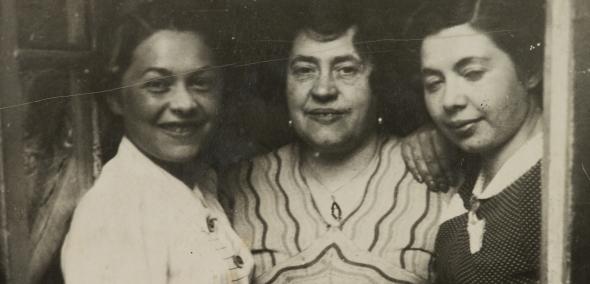 Fotografia z archiwum Muzeum POLIN. Przedstawia trzy kobiety, które pozują przytulone do siebie. Od lewej: Miriam Justman, Regina Justman, Paulina Włodawer