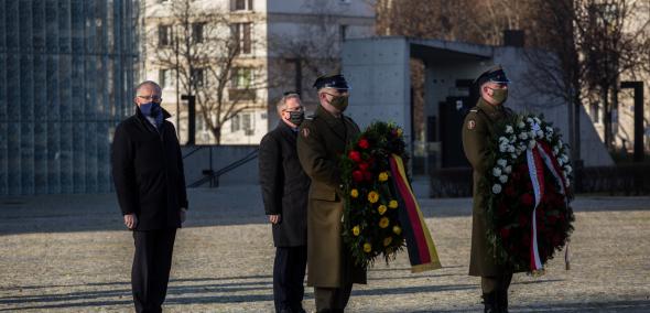 Szef Urzędu Prezydenta Federalnego Republiki Federalnej Niemiec Stephan Steinlein oraz szef gabinetu Prezydenta RP Krzysztof Szczerski podczas złożenia wieńca przed pomnikiem Bohaterów Getta Warszawskiego przed nimi żołnierze w mundurach galowych niosą wieńce z kwiatów