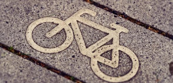 Na obrazie widzimy symbol roweru, narysowany na kostce, która wybrukowana jest ścieżka rowerowa. 