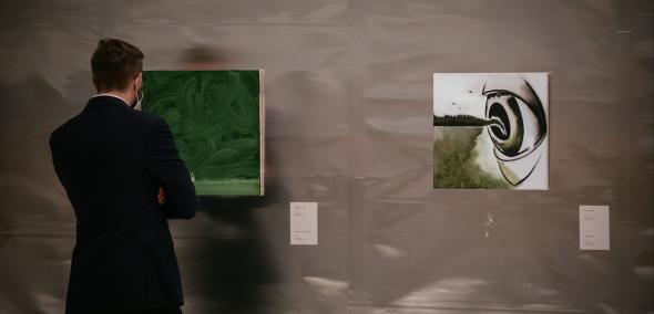 Człowiek stoi przed obrazem Wilhelma Sasnala "Shoah"