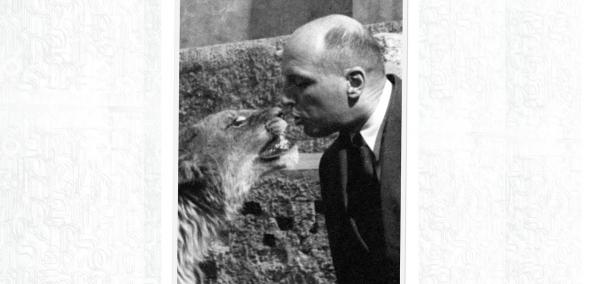 Czarno-białe zdjęcie przedstawia Jana Żabińskiego całującego lwa.
