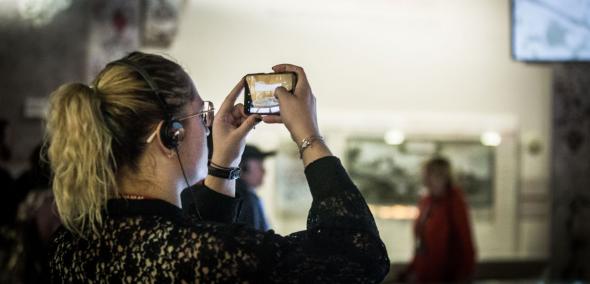 Kobieta robi zdjęcie smartfonem na wystawie stałej w Muzeum POLIN.