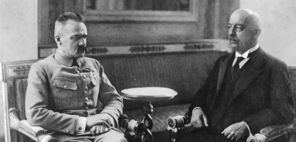 Gabriel Narutowicz z Józefem Piłsudskim siedzą obok siebie podczas spotkania w Belwederze.