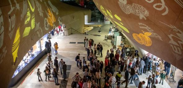 Tłum osób stoi w holu Muzeum POLIN podczas Rodzinnej Chanuki 2022.