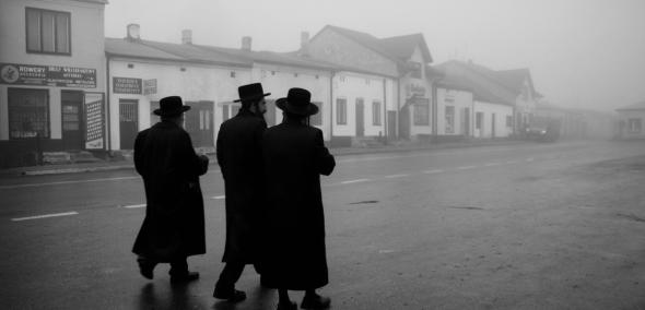 Trzej chasydzi idą po ulicy jakiegoś miasta. Fotografia Agnieszki Traczewskiej z serii Powroty.