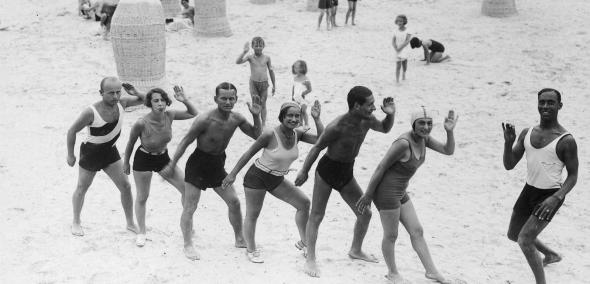 Grupa kuracjuszy podczas lekcji tańca na plaży prowadzonej przez czarnoskórego Sama z zespołu Kataszka.