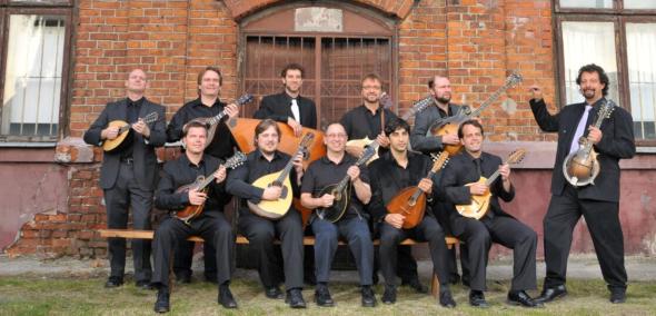 Members of the Ger Mandolin Orchestra sit or stand, holding mandolins in their hands.