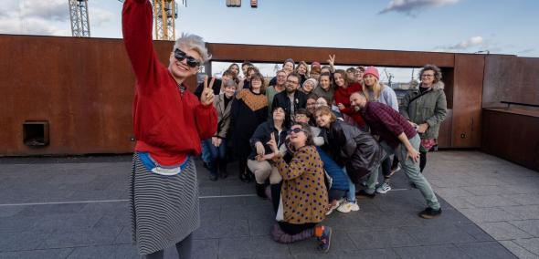 Grupa osób na dachu Europejskiego Centrum Solidarności robi "selfie".