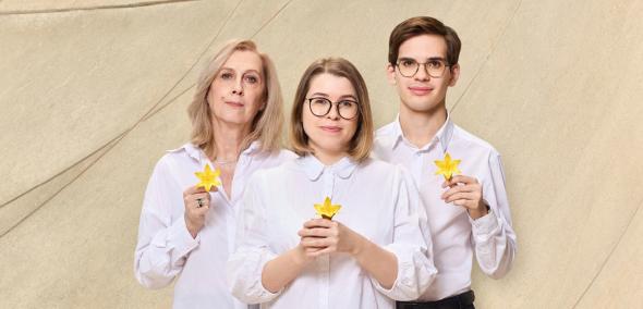 Troje wolontariuszy akcji Żonkile trzyma przed sobą papierowe kwiaty symbolizujące akcję.