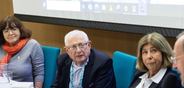 Cztery osoby - prelegenci i prelegentki spotkania - siedzą przy stole w sali konferencyjnej. 