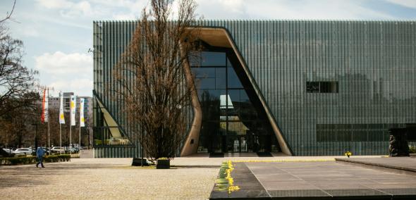 Budynek Muzeum POLIN i pomnik Bohaterów Getta w otoczeniu kwitnących żonkili.