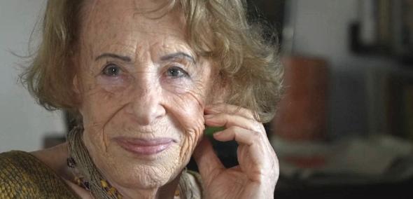 Irena Agata Bołdok - starsza uśmiechnięta kobieta z krótkimi włosami. W tle regał z książkami.