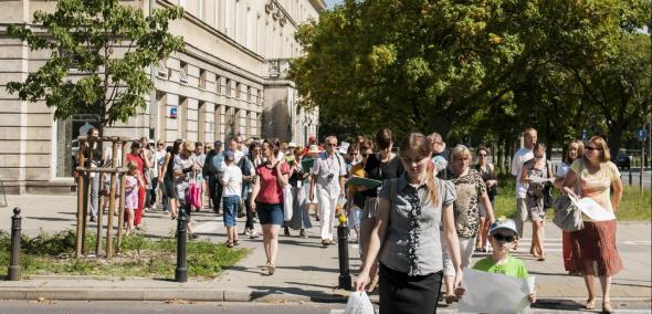 duża grupa uczestników spaceru miejskiego organizowanego przez Muzeum Polin na tle budynku przy ulicy Zamenhofa w Warszawie