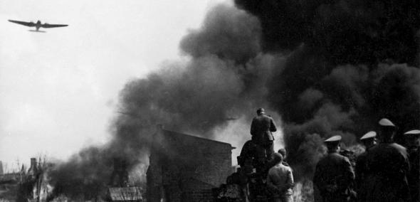 Dym nad Warszawą w 1939 r. Na niebie widać samolot.