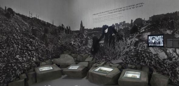 Na zdjęciu: Fragment galerii "Zagłada" z przedstawieniem powiększonego zdjęcia powojennych ruin Warszawy. Po gruzowisku z trudem przemieszczają się dwie osoby.