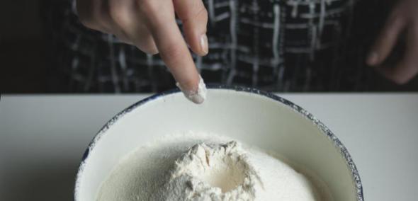 TISZ Festiwal: Finisaż. Na zdjęciu widać miskę przesianej mąki, która stoi na stole. W mące zrobione zagłębienie, na rozczyn drożdży - stoi on obok, przygotowany do wymieszania z mąką