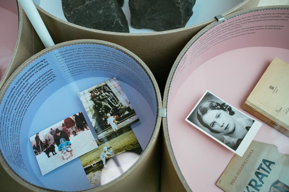 W Tubach z kartony, których wnętrze jest w kolorach pastelowych - niebieskim i różowym - znajdują się pamiątki mieszkańców Muranowa: fotografie, ulotki, książki