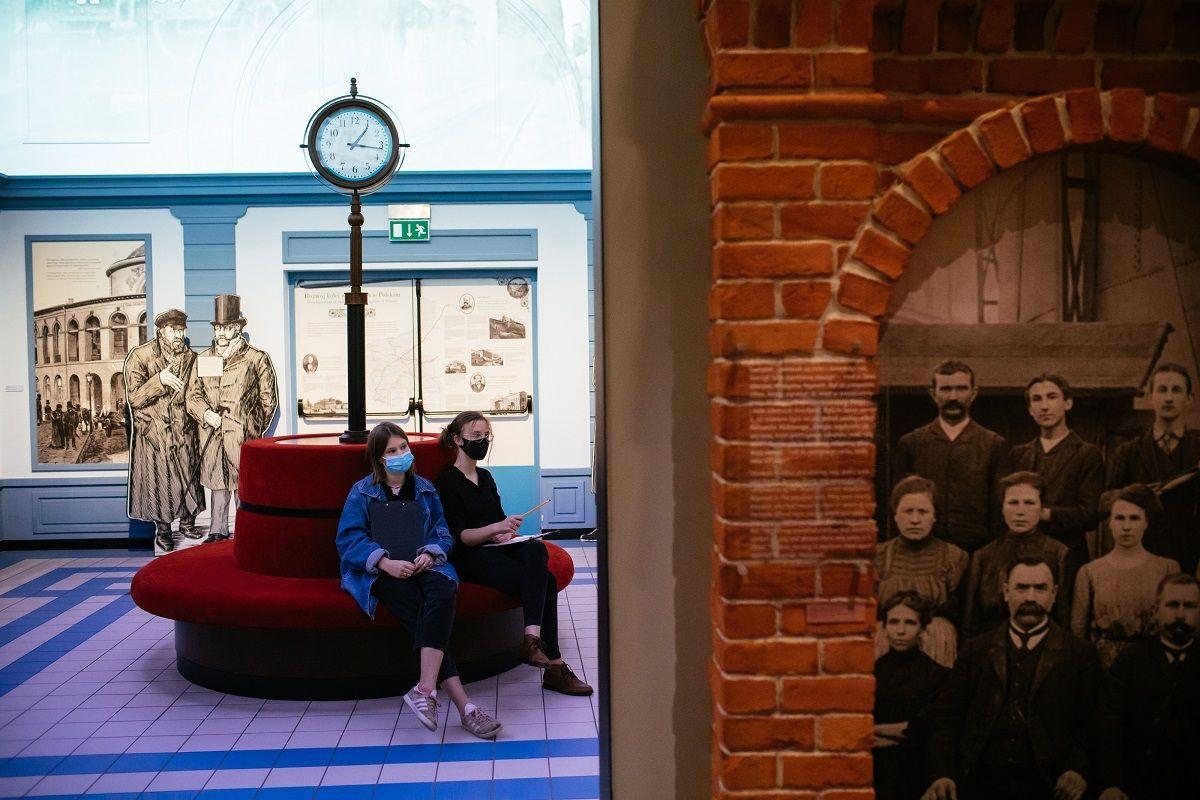 Dwie kobiety siedzą w galerii Wyzwania nowoczesności w Muzeum POLIN. Ta galeria opowiada o migracji Żydów.