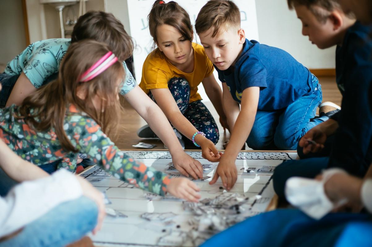 Dzieci podczas wspólnej zabawy dotykają planszy.