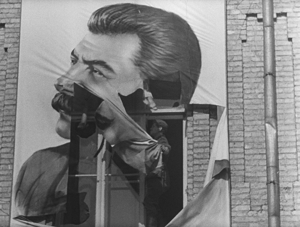 Kadr z filmu "Babi Jar. Konteksty". Mężczyzna odsłania plakat Stalina.