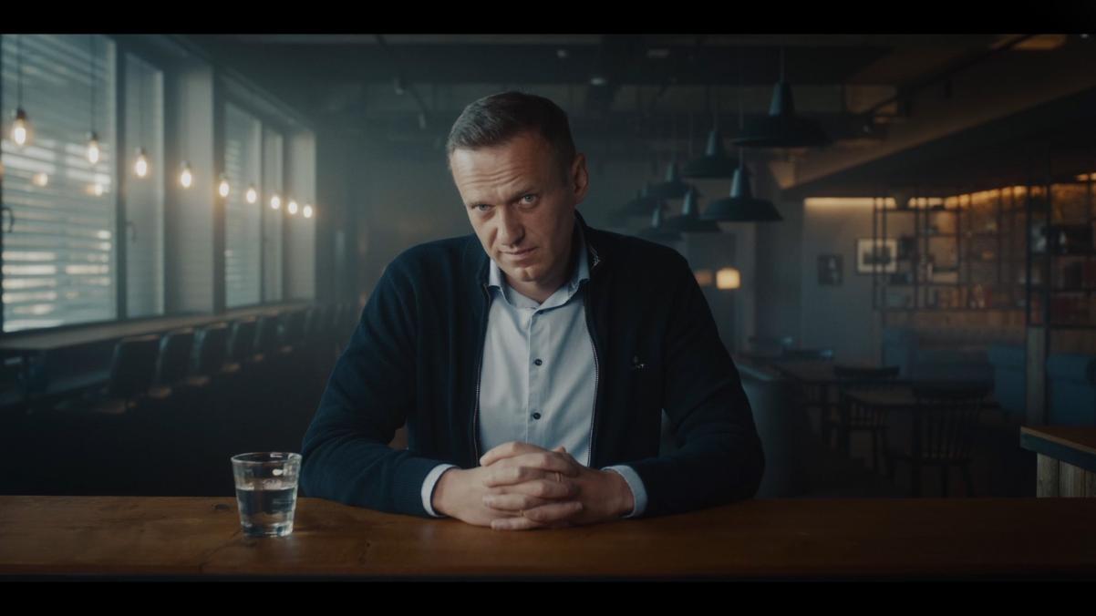 Aleksiej Nawalny siedzi przy stole.