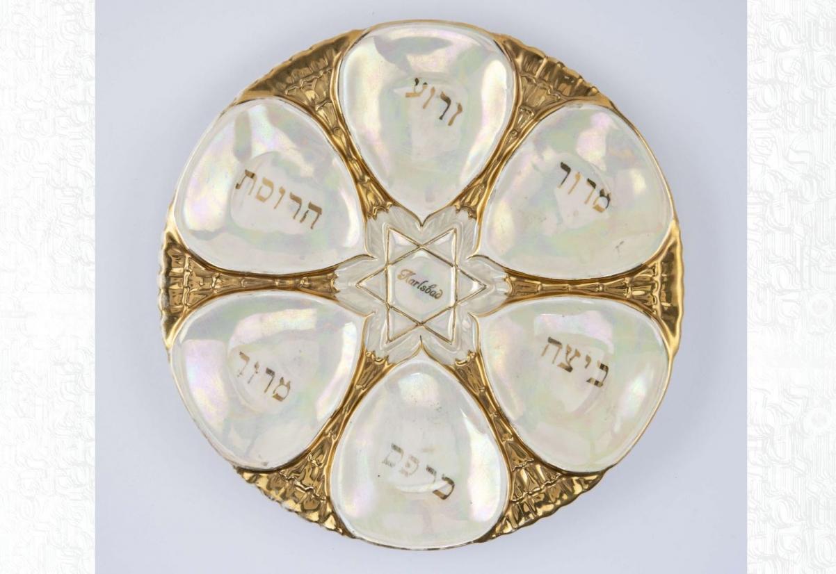 Okrągły talerz sederowy, używany podczas święta Pesach, z sześcioma wgłębieniami na tradycyjne dla tego święta produkty spożywcze. Wewnątrz każdego wgłębienia inskrypcje w języku hebrajskim. Na środku talerza złota gwiazda Dawida.