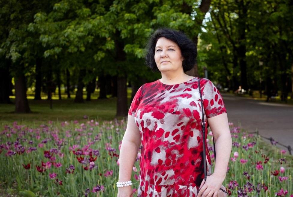 Przewodniczka Katarzyna Jakubowicz w parku. Jest ubrana w czerwoną sukienkę.