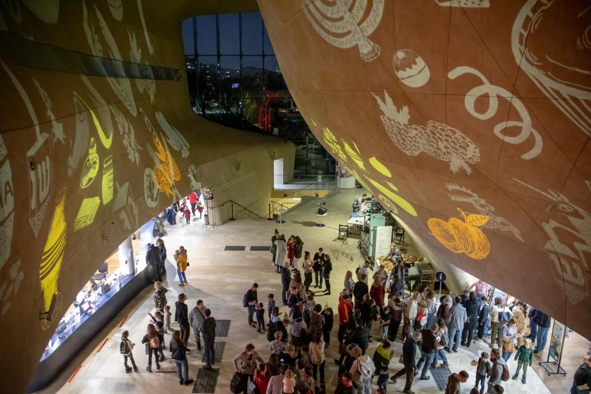 Tłum osób stoi w holu Muzeum POLIN podczas Rodzinnej Chanuki 2022.