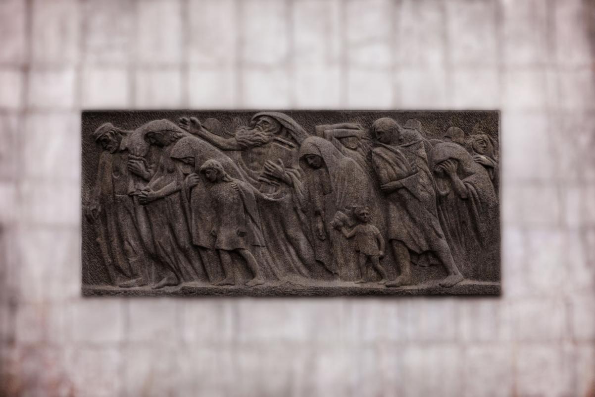 Relief na drugiej stronie pomnika Bohaterów Getta przedstawiający pochód cywilów.