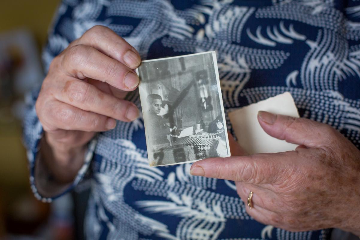 Krystyna Budnicka trzyma w dłoniach czarno-białą fotografię ojca.